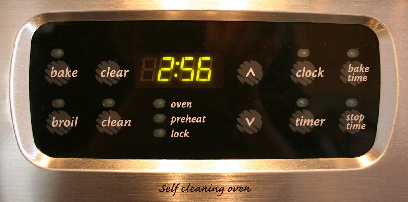 A photograph of a digital clock display built into a kitchen oven, showing the time.
